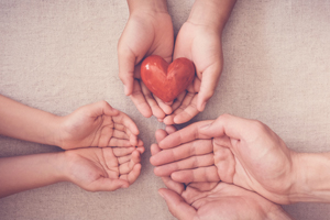 Photo illustration of hands holding a heart